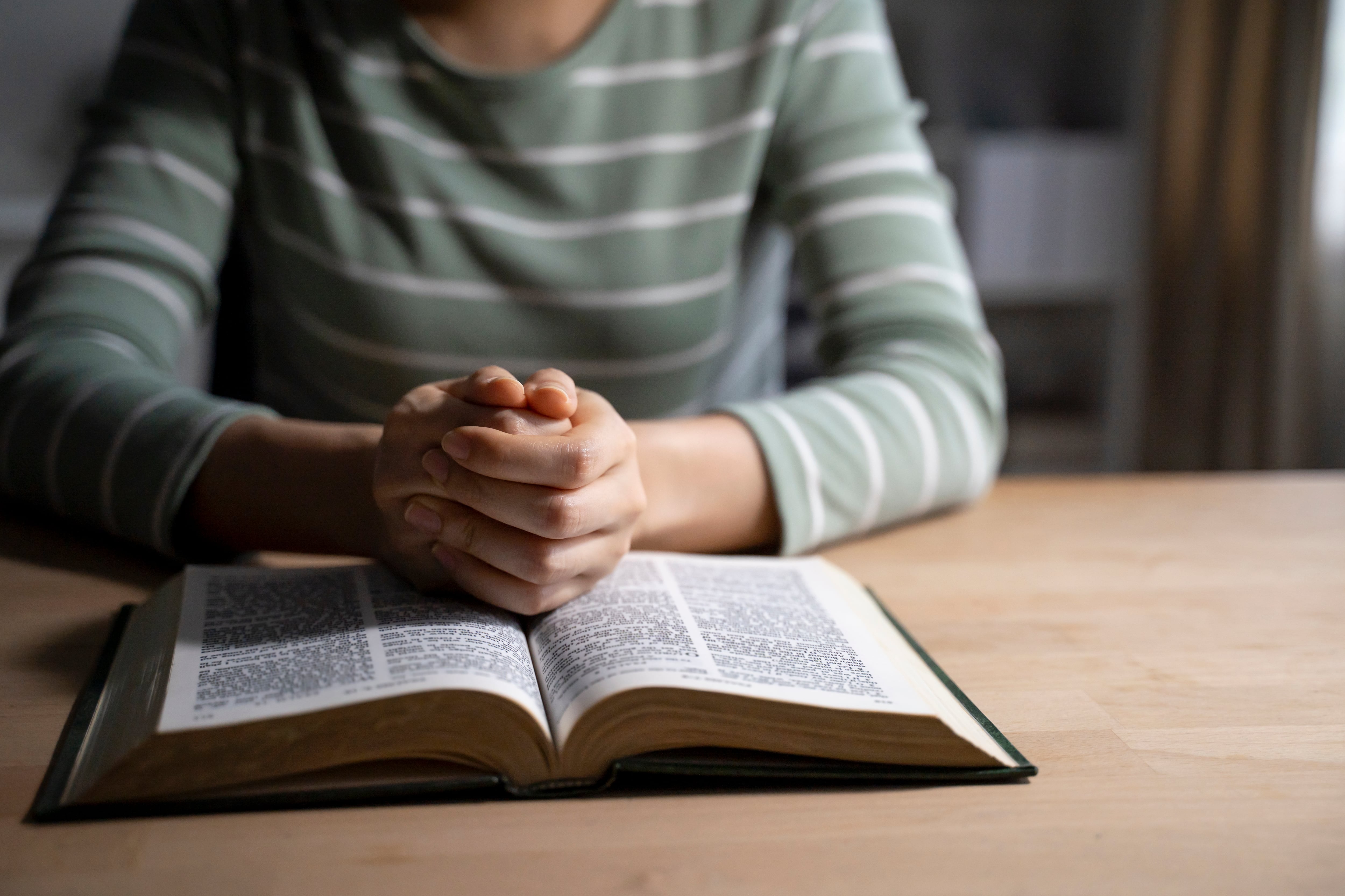 Mujer leyendo la Biblia en la mesa (Foto vía Getty Images)