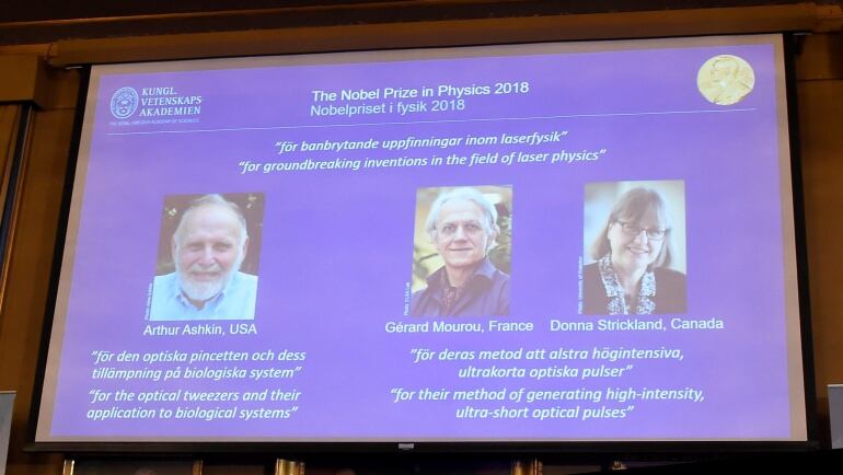 Los retratos de los tres ganadores del Nobel de Física, el estadounidense Arthur Ashkin (izq), el francés Gérard Mourou (c) y la canadiense Donna Strickland