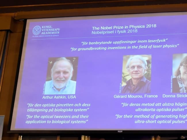 Los retratos de los tres ganadores del Nobel de Física, el estadounidense Arthur Ashkin (izq), el francés Gérard Mourou (c) y la canadiense Donna Strickland