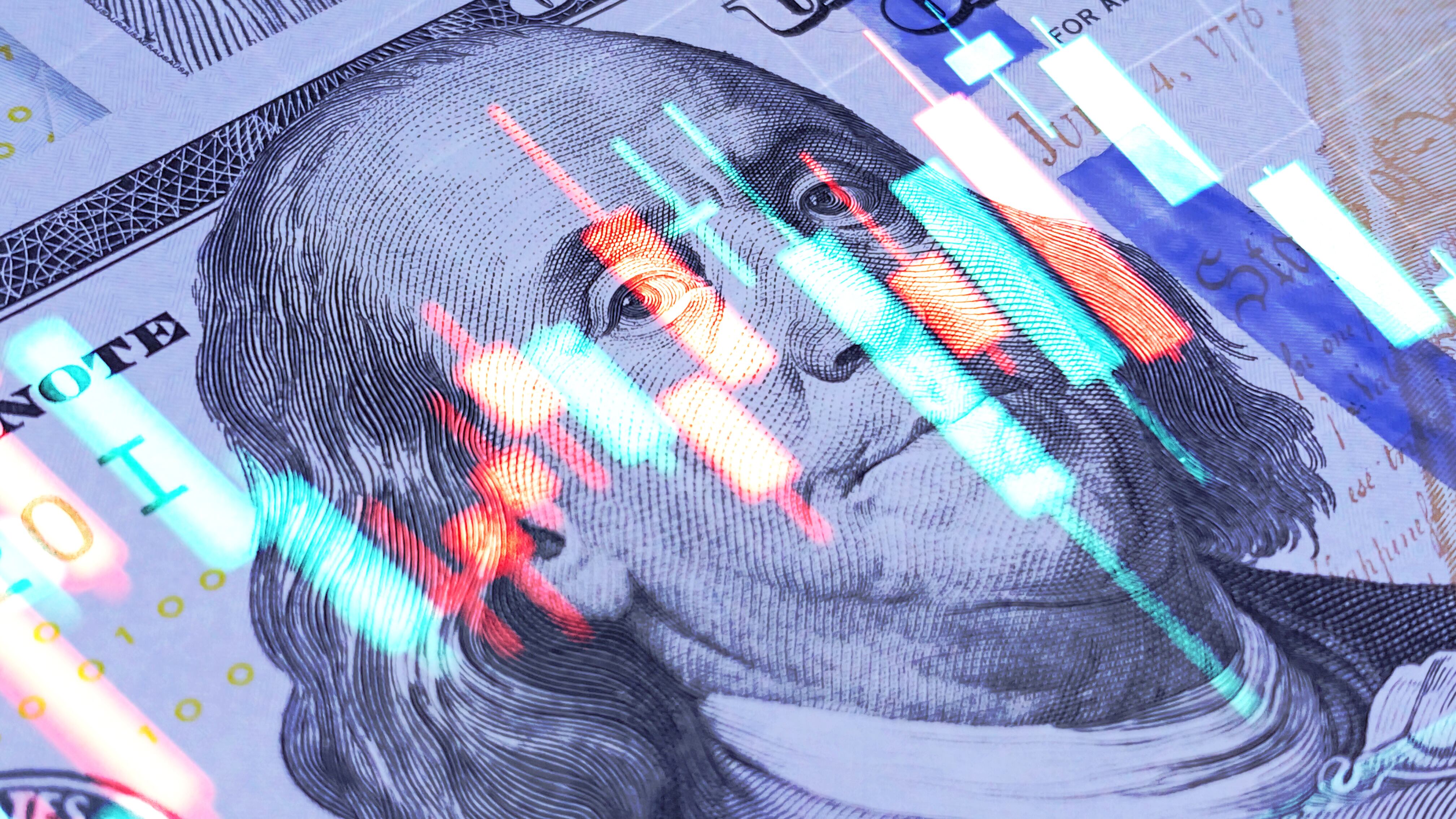Diagrama de indicadores económicos sobre un billete de 100 dólares estadounidenses (Getty Images)