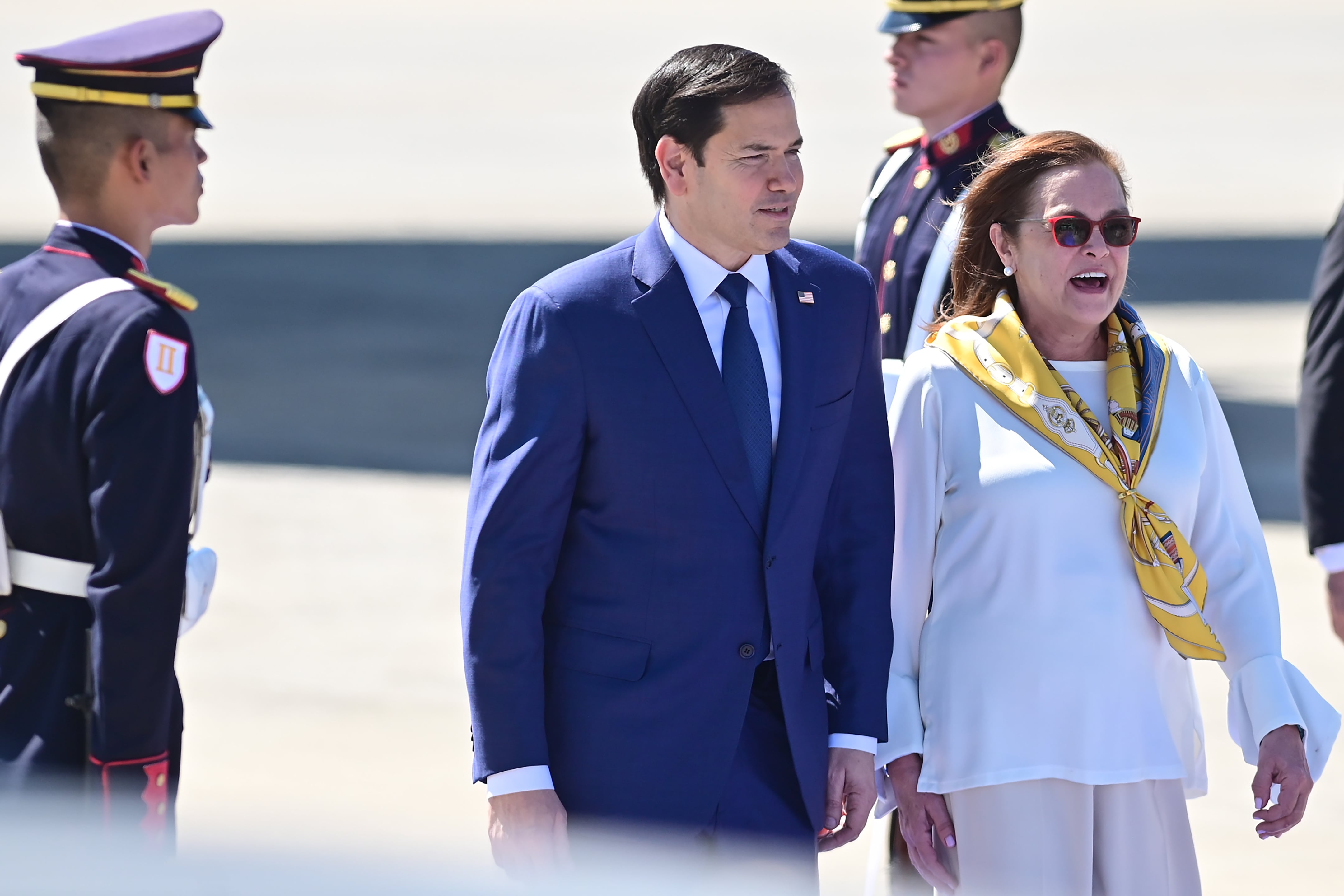 AME6653. SAN LUIS TALPA (EL SALVADOR), 03/02/2025.- El secretario de Estado de los Estados Unidos, Marco Rubio (c), camina junto a la canciller de El Salvador Alexandra Hill Tinoco este lunes, en el aeropuerto internacional Óscar Arnulfo Romero en San Luis Talpa (El Salvador). Rubio llegó a El Salvador para reunirse con el presidente del país, Nayib Bukele, uno de los principales aliados en Latinoamérica de la nueva Administración de Donald Trump. EFE/ STR