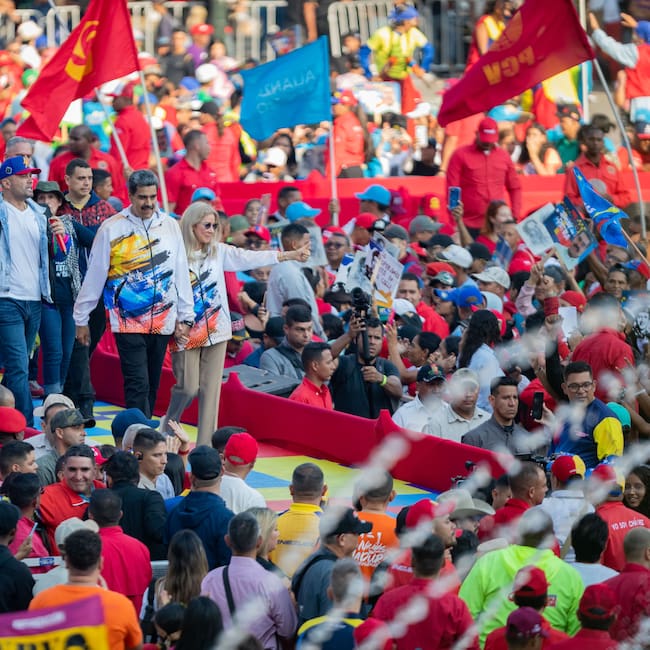 AME2344. CARACAS (VENEZUELA), 25/03/2024.- El presidente de Venezuela, Nicolás Maduro, junto a su esposa la primera dama, Cilia Flores, saluda luego de hacer oficial su candidatura a las presidenciales del próximo 28 de julio, en las que competirá por un tercer período en el poder, este lunes en la sede del Consejo Nacional Electoral (CNE) en Caracas (Venezuela). El líder chavista acudió a la sede del ente electoral tras participar en una marcha convocada por el gobernante Partido Socialista Unido de Venezuela (PSUV) en respaldo a su inscripción, con la que se convierte en el décimo político en oficializar su aspiración, a pocas horas de que concluya el plazo establecido en el cronograma para la presentación de candidaturas. EFE/ Rayner Peña R.