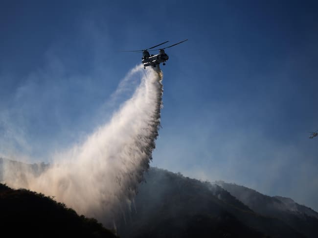 Simi Valley (United States), 04/07/2024.- A helicopter drops water on the Sharp Fire as fire crews battle the fire in Simi Valley, California, USA, 03 July 2024.