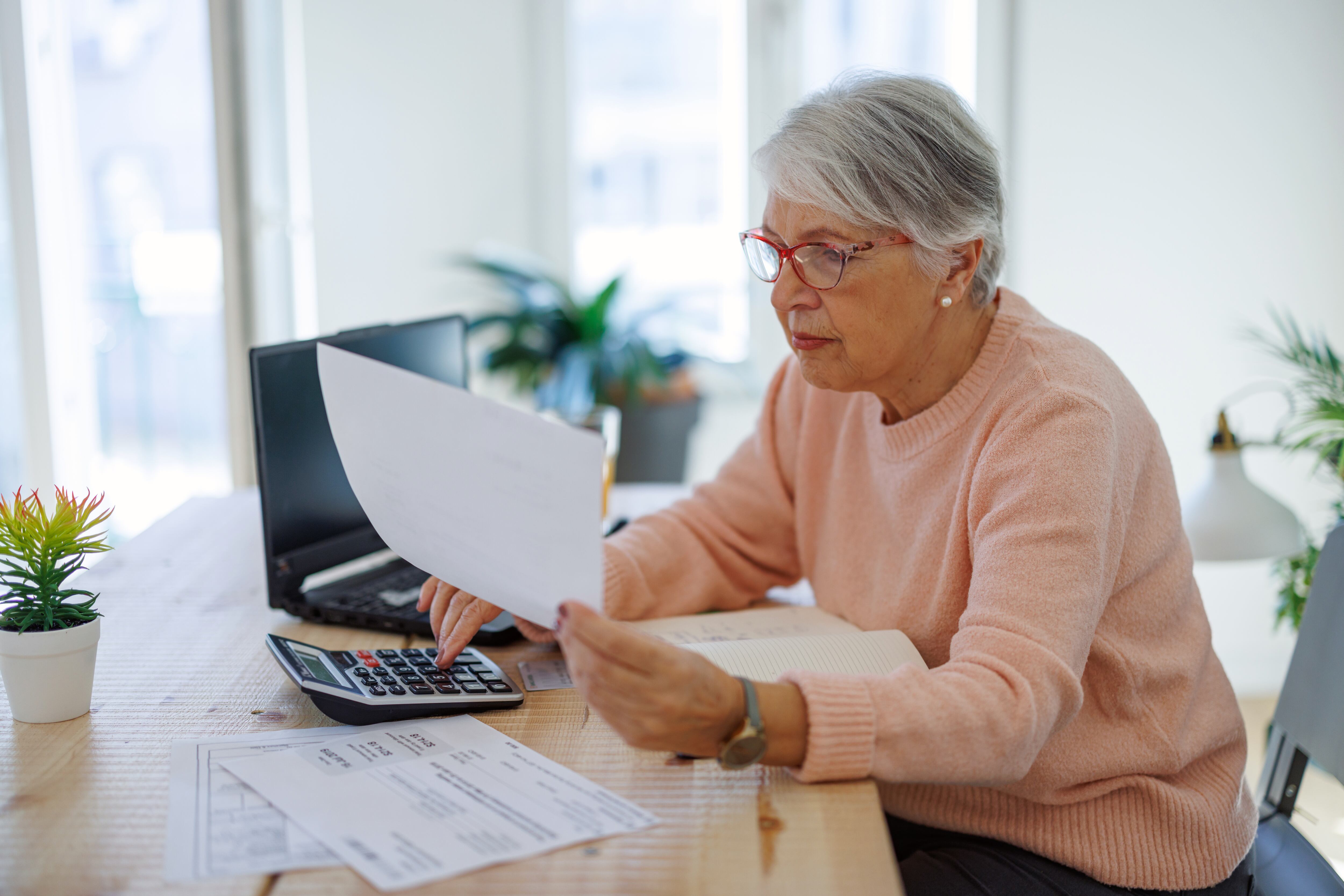 Adulta mayor haciendo cuentas de sus finanzas (Foto vía Getty Images)
