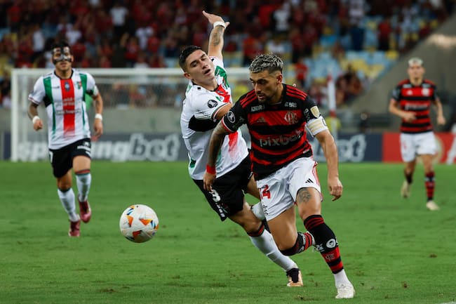 AMDEP9520. RÍO DE JANEIRO (BRASIL), 10/04/2024.- Giorgian De Arrascaeta (d) de Flamengo disputa un balón con Benjamín Rojas Ferrera de Palestino este miércoles, en un partido de la fase de grupos de la Copa Libertadores entre Flamengo y Palestino en el estadio Maracanã en Rio de Janeiro (Brasil). EFE/ Antonio Lacerda