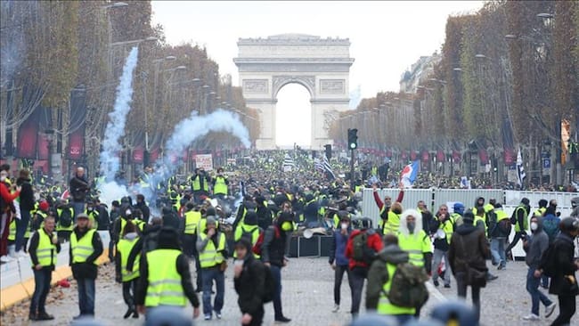 Los manifestantes de chalecos amarillos (Gilet jaune) se enfrentan a la policía antidisturbios durante una protesta contra el aumento del precio del petróleo en los Campos Elíseos en París, Francia. Foto: Agencia Anadolu