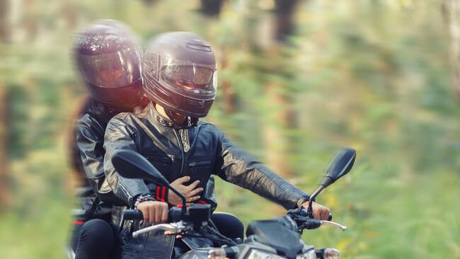 Pareja montando moto en el bosque (Getty Images)