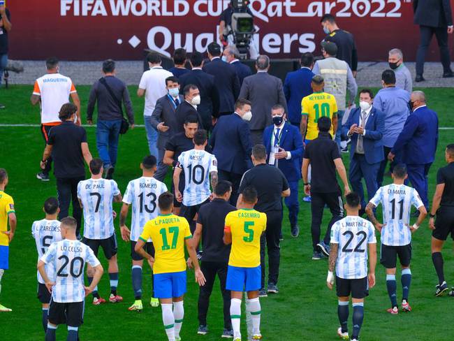 Los jugadores de Argentina y Brasil abandonan el campo de juego tras la intervención de las autoridades sanitarias.