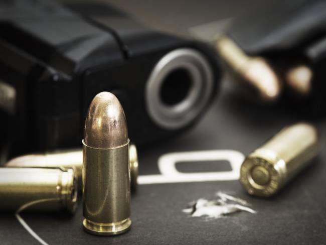Imagen de referencia de pistola con balas. Foto: Getty Images.